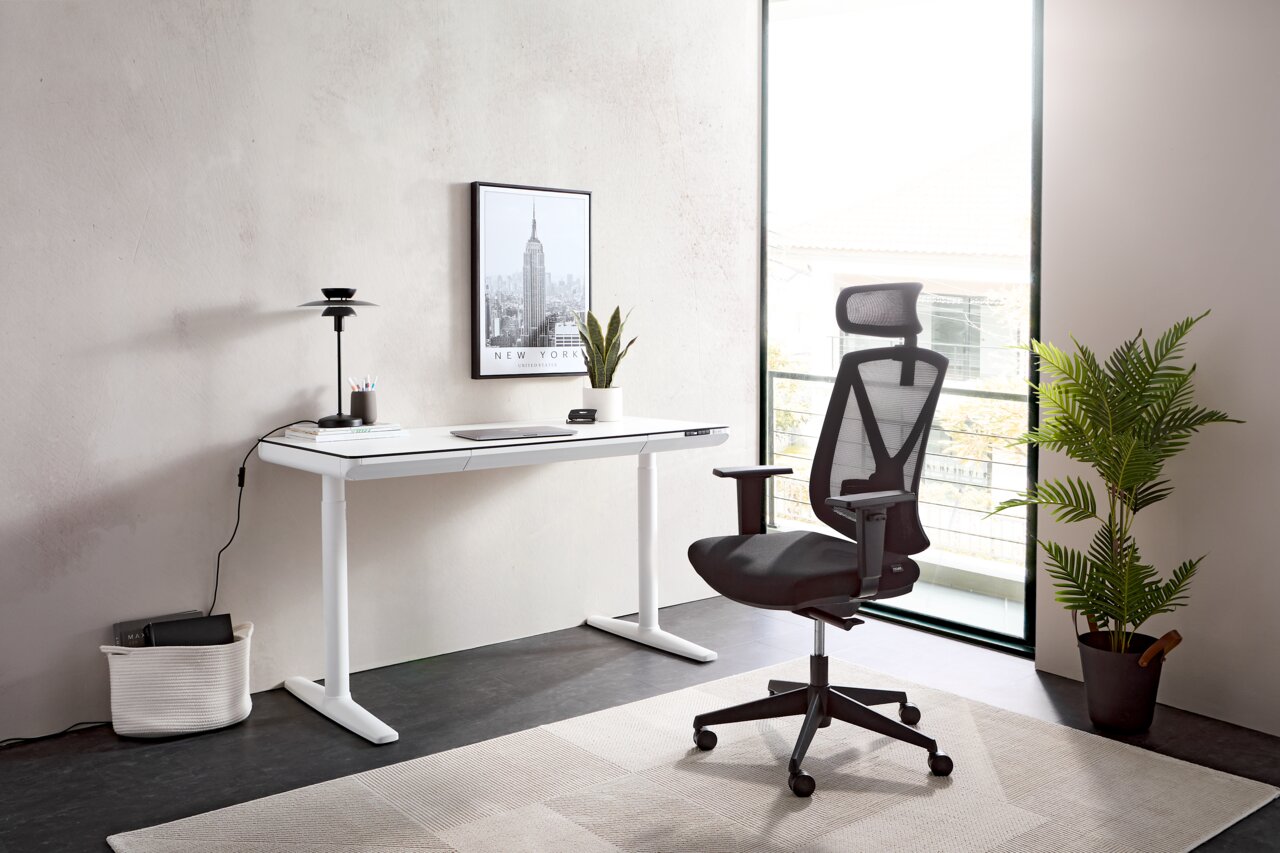 Moderner E-Schreibtisch in einem hellen Raum, seitliche Perspektive, mit ergonomischem Bürostuhl und Dekoration.