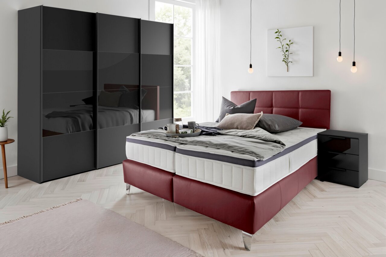 Schwarzer dreitüriger Schwebetürenschrank in einem modernen Schlafzimmer, seitliche Perspektive