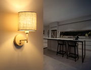 Moderne Wandleuchte mit Stoffschirm, seitliche Perspektive, beleuchtet eine stilvolle Küche.