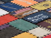 Nahaufnahme eines Lederteppichs aus verschiedenen bunten Lederetiketten, die in einem Patchwork-Muster zusammengenäht sind.