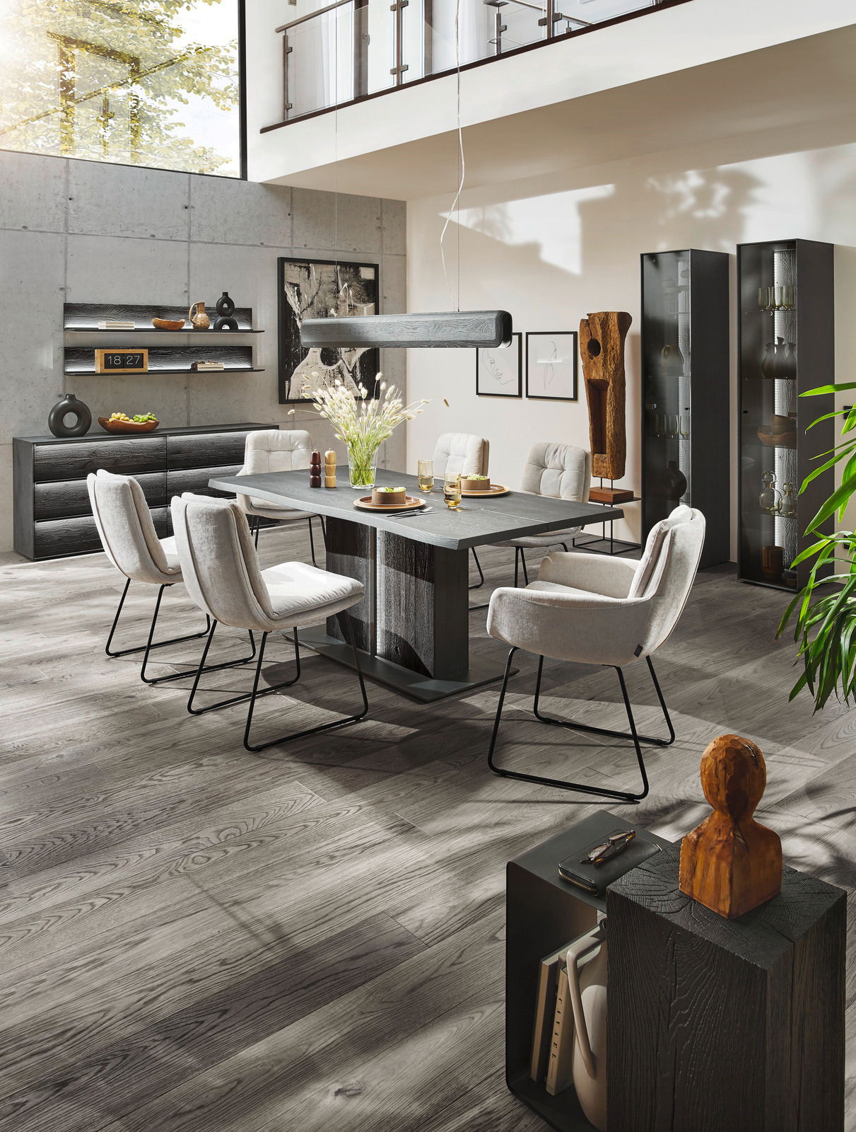 Moderne Esszimmer-Einrichtung mit Esstisch, Stühlen und Vitrinen in einem hellen Raum mit hohen Decken, seitliche Perspektive.