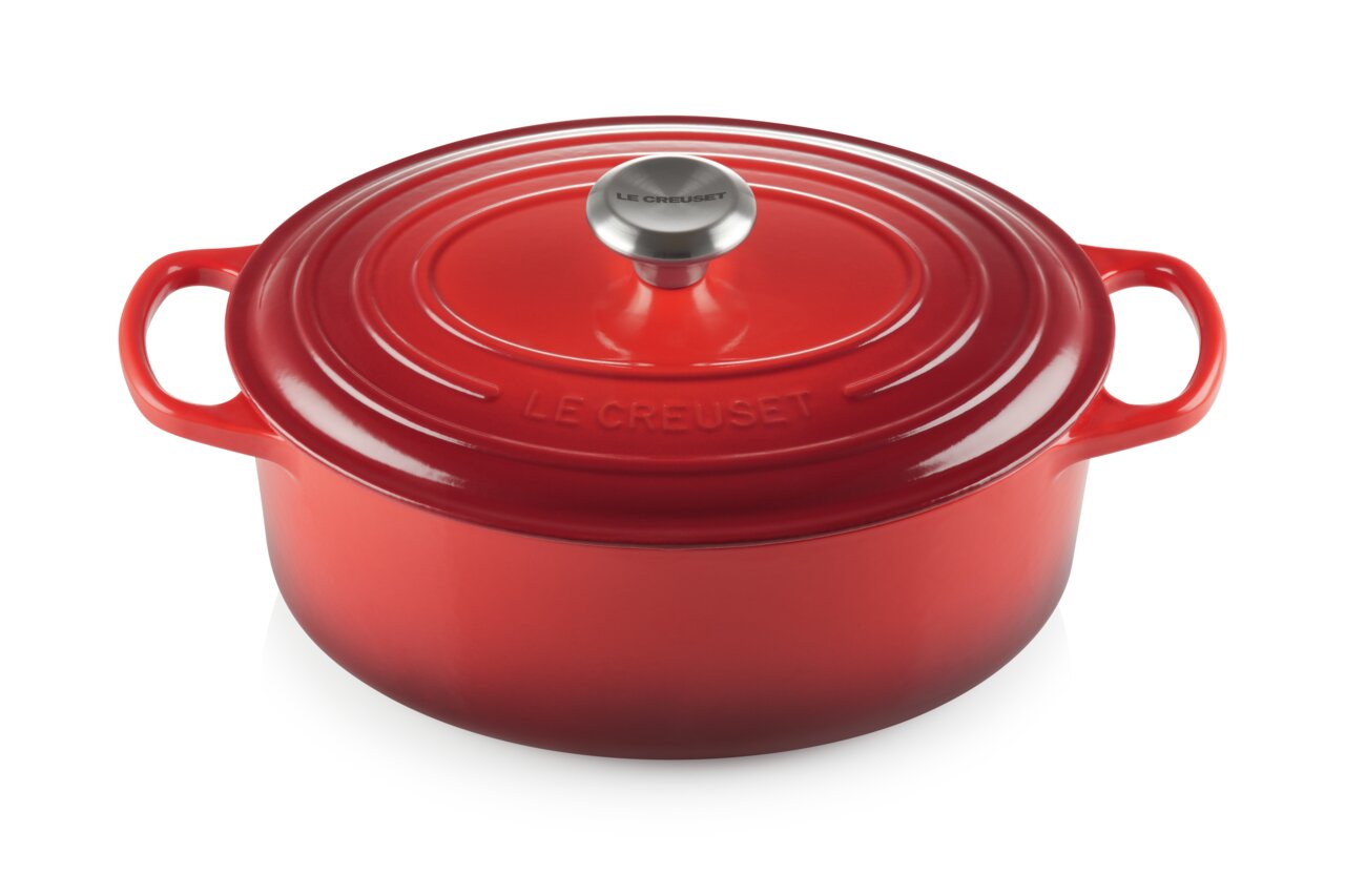 Rode ovale braadpan van Le Creuset uit de Signature-serie, gezien vanuit een schuine hoek van bovenaf