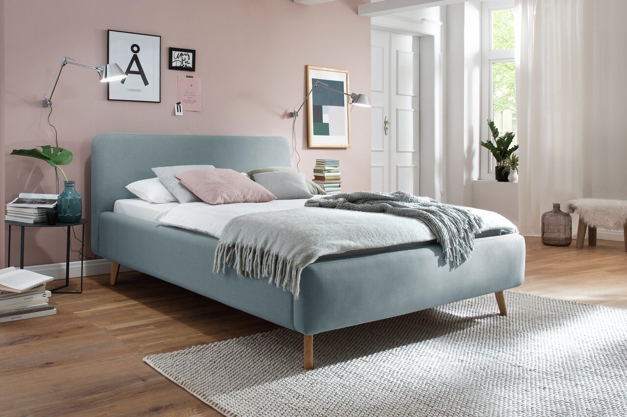 Modern gestoffeerd bed in een stijlvolle slaapkamer, zijaanzicht