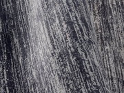 Nahaufnahme eines Designer Teppichs mit grauem und schwarzem Muster in diagonaler Perspektive