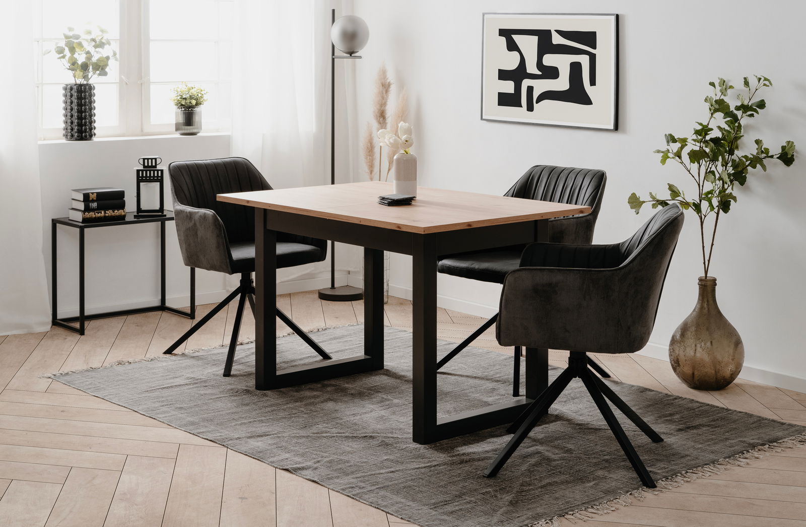 Moderner Esstisch mit Holzplatte und schwarzen Metallbeinen, umgeben von vier gepolsterten Stühlen in einem stilvoll eingerichteten Raum, seitliche Perspektive.