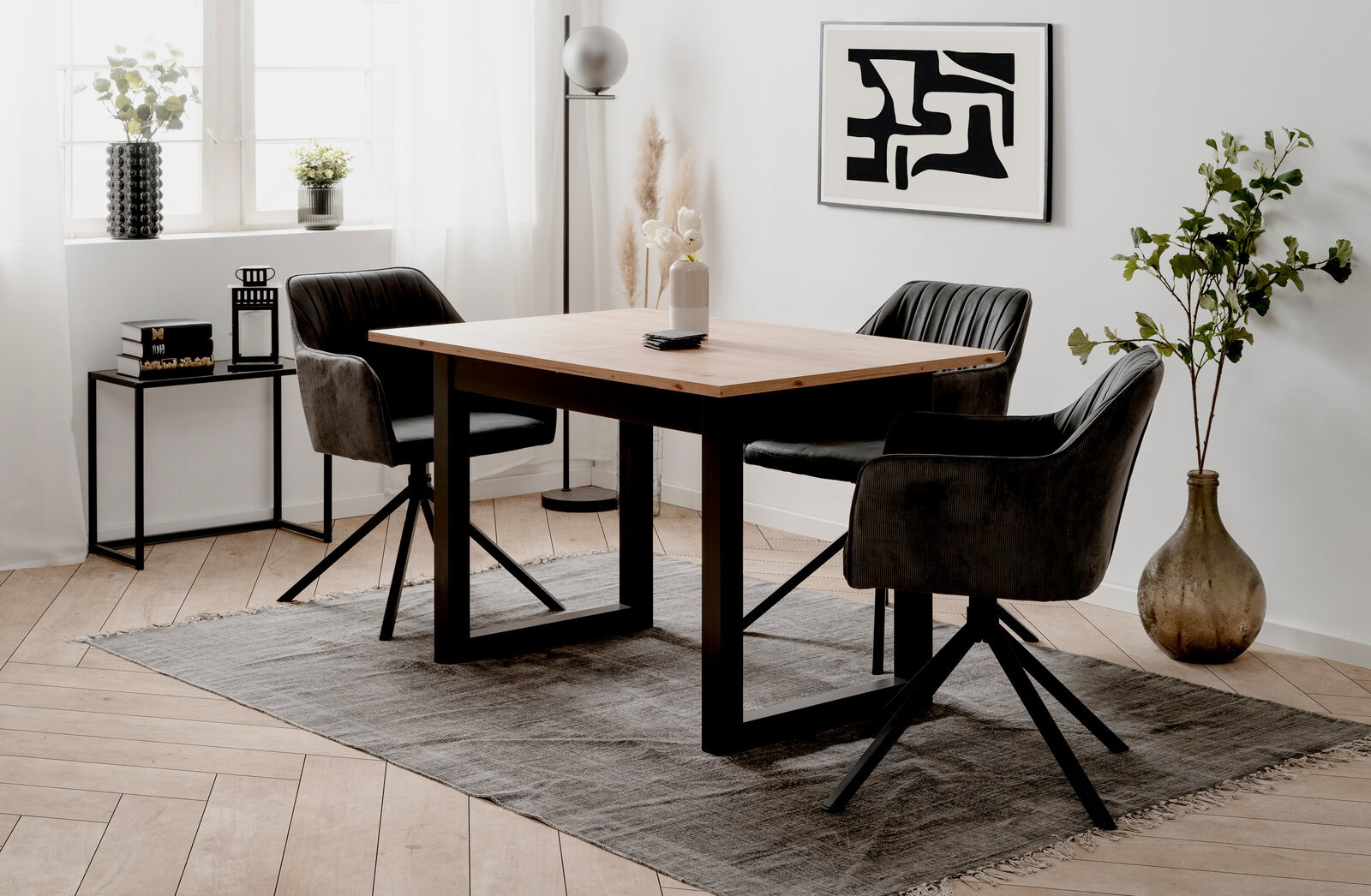 Moderner Esstisch mit Holzplatte und schwarzen Metallbeinen, umgeben von vier gepolsterten Stühlen in einem stilvoll eingerichteten Raum, seitliche Perspektive.