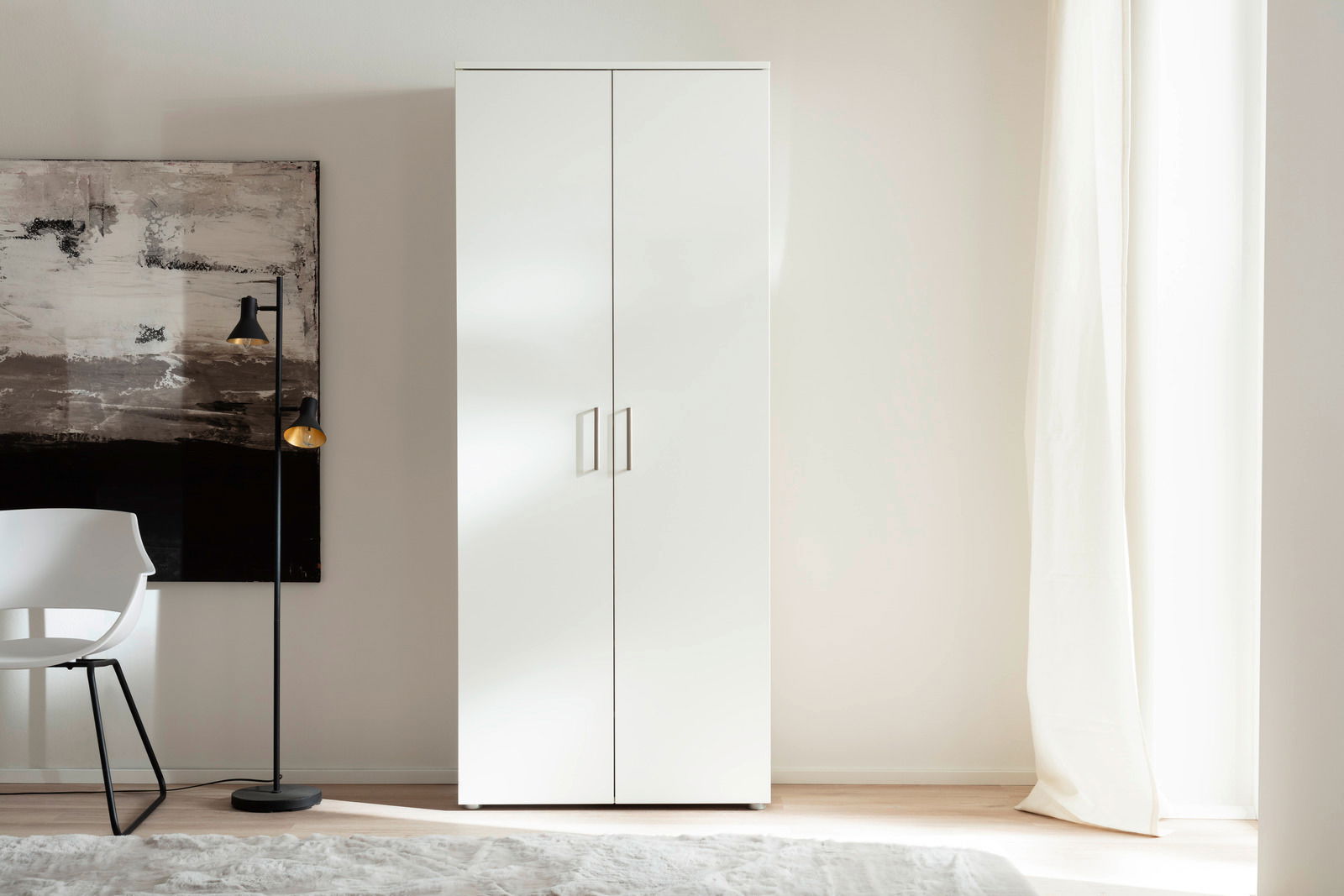 Weißer, hoher Schuhschrank mit zwei Türen, frontal fotografiert, neben einem modernen Stuhl und einer Stehlampe.