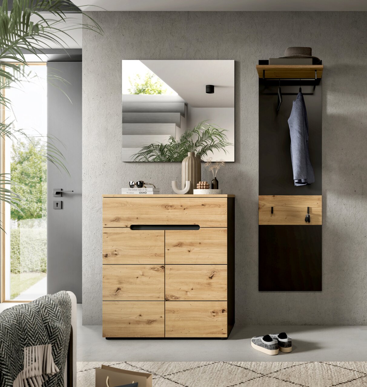 Moderne Garderobe im Flur: Holz-Schuhschrank mit schwarzer Griffleiste, quadratischer Wandspiegel und Garderobenpaneel mit Ablage und Haken, frontal aus Augenhöhe fotografiert.