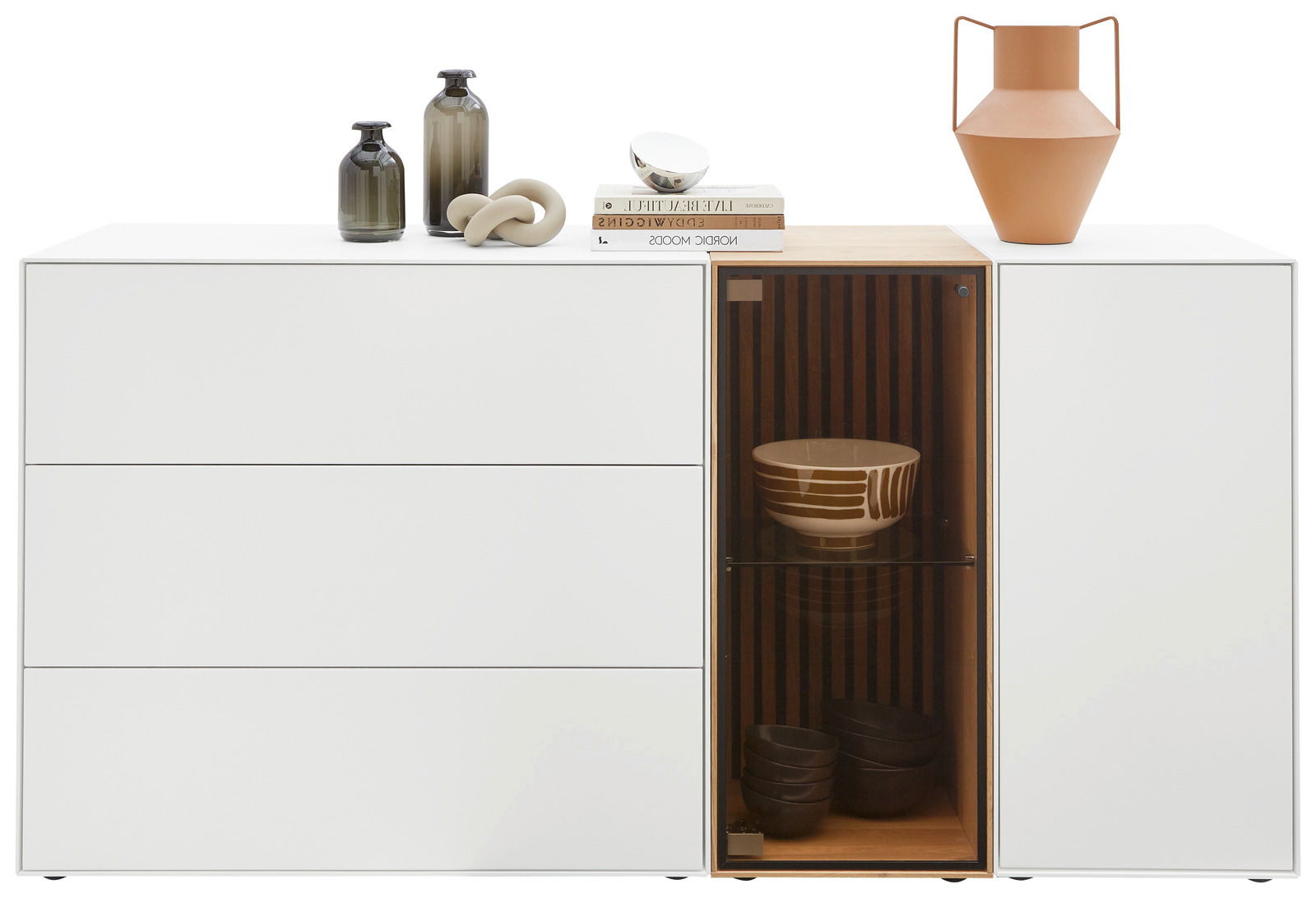 Modernes Sideboard mit drei Schubladen links und einem Glaselement rechts, dekoriert mit Vasen und Büchern, Frontalansicht.