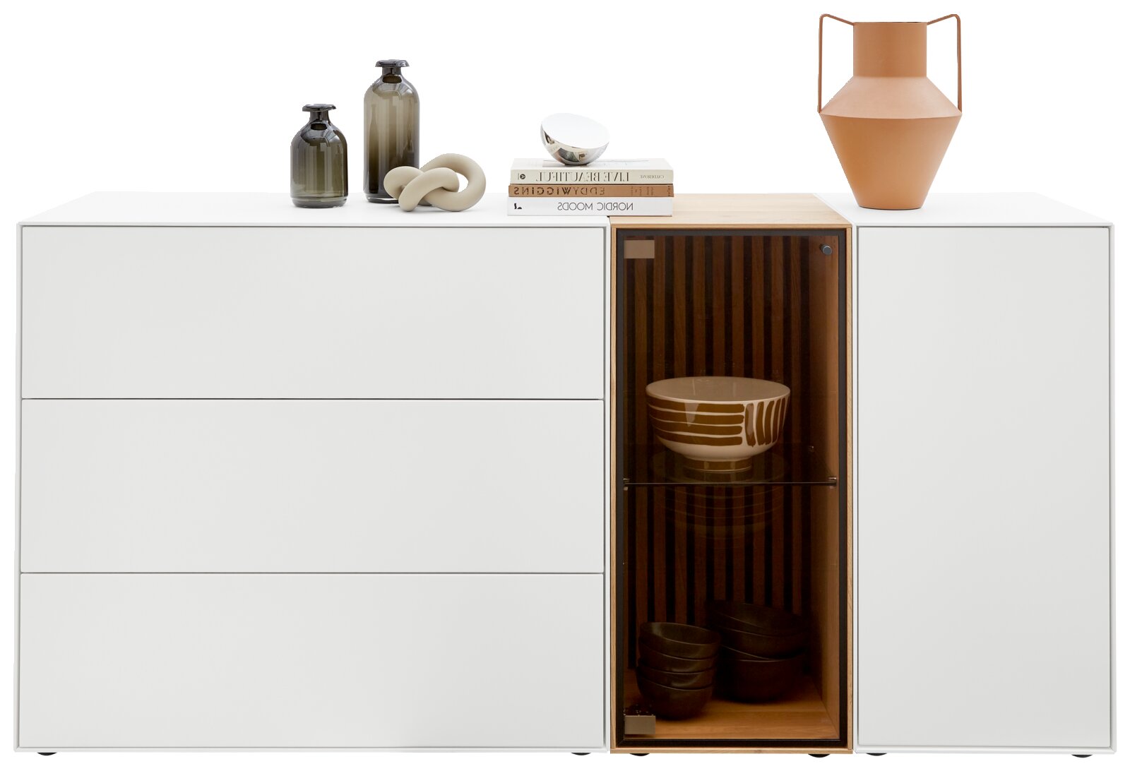 Modernes Sideboard mit drei Schubladen links und einem Glaselement rechts, dekoriert mit Vasen und Büchern, Frontalansicht.