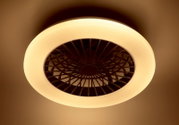 Deckenventilator mit integriertem Licht, von unten betrachtet, in warmem Gelbton leuchtend.