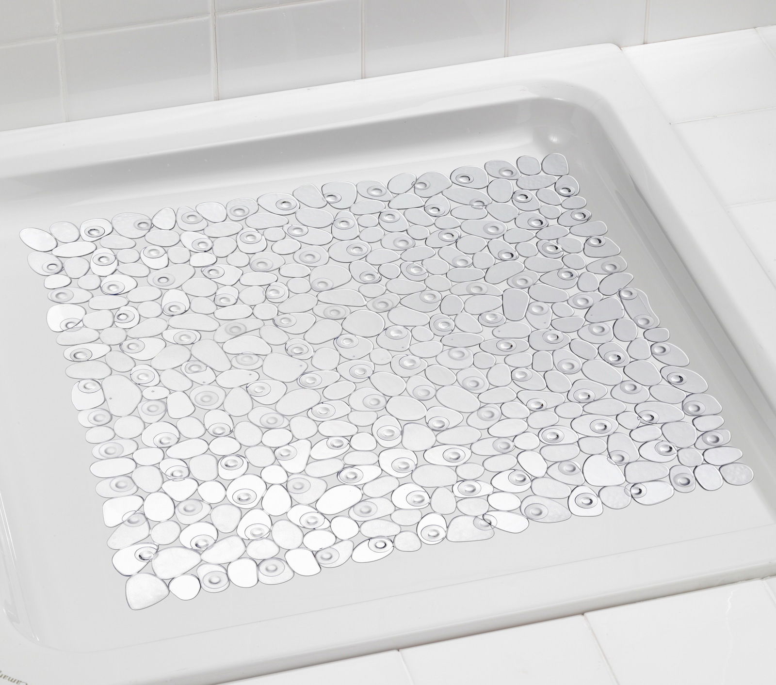 Transparente Duscheinlage mit rutschfestem Design in einer weißen Duschwanne, von oben betrachtet.