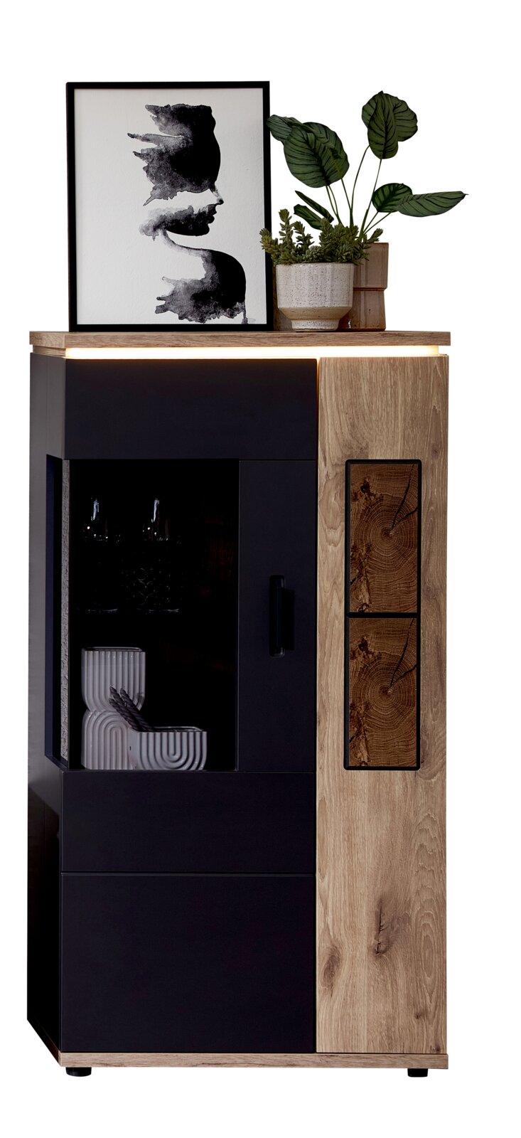 Moderne Vitrine/Highboard in Schwarz und Eicheoptik mit LED-Lichtleiste, Glastür links und Holzfront mit markanten Holzquerschnitt-Akzenten rechts; Frontansicht leicht schräg von vorn.