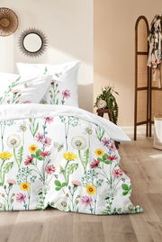 Bettwäsche mit buntem Blumenmuster, fotografiert aus einer seitlichen Perspektive im Schlafzimmer.