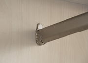 Nahaufnahme einer Kleiderstange in einem Drehtürenschrank, montiert an einer hellen Holzplatte.