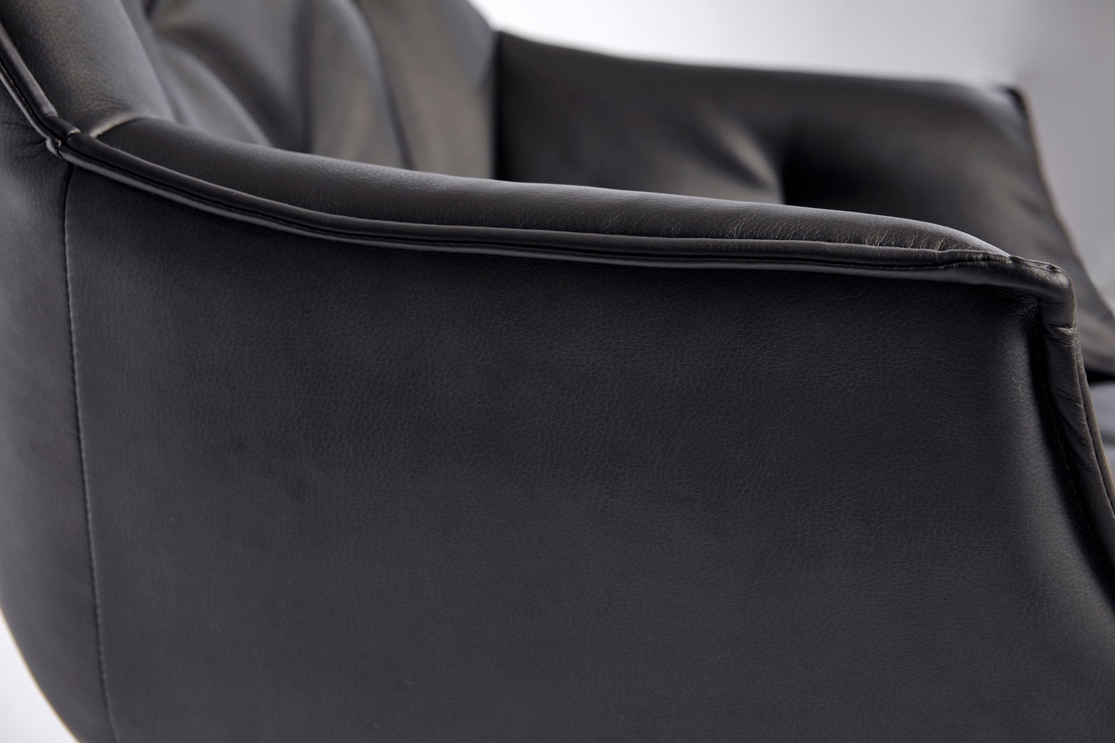 Nahaufnahme eines schwarzen Bürostuhls aus Leder, seitliche Perspektive