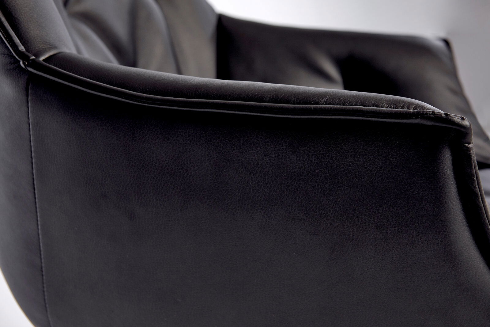 Nahaufnahme eines schwarzen Bürostuhls aus Leder, seitliche Perspektive