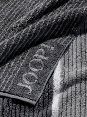 Graues Duschtuch mit eingewebtem Logo, Nahaufnahme der Textur und Kante.