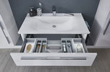 Moderne Badkombination mit Waschbecken und geöffneter Schublade, von oben betrachtet. Enthält diverse Pflegeprodukte und Accessoires.