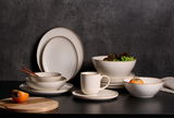 Elegantes Geschirrset in Beige mit Tellern, Schalen und Tasse, seitliche Perspektive