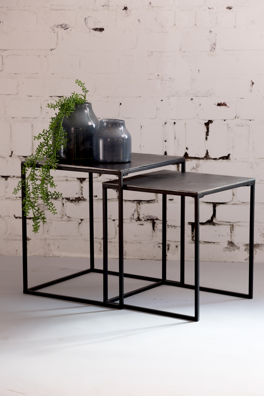 Light&Living Beistelltisch BANOS Zwei ineinander verschachtelte Beistelltische aus Metall mit dunkler Oberfläche, dekoriert mit zwei blauen Vasen und einer hängenden Pflanze, seitliche Perspektive.