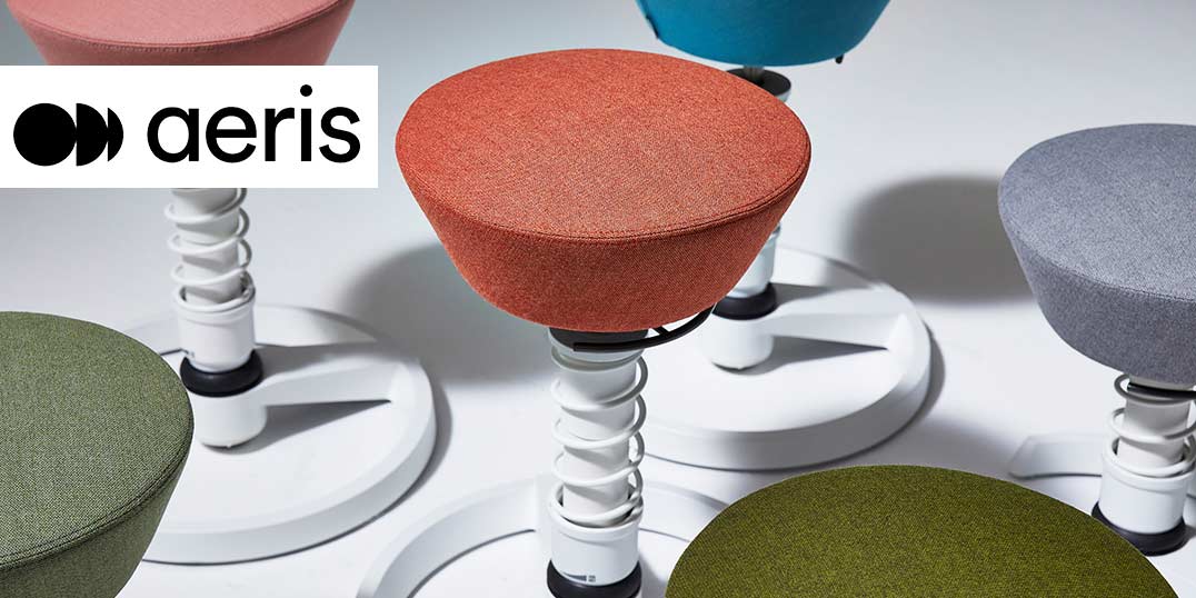 Een collectie kleurrijke, ergonomische krukken met binnenvering in groen, oranje, blauw en grijs.