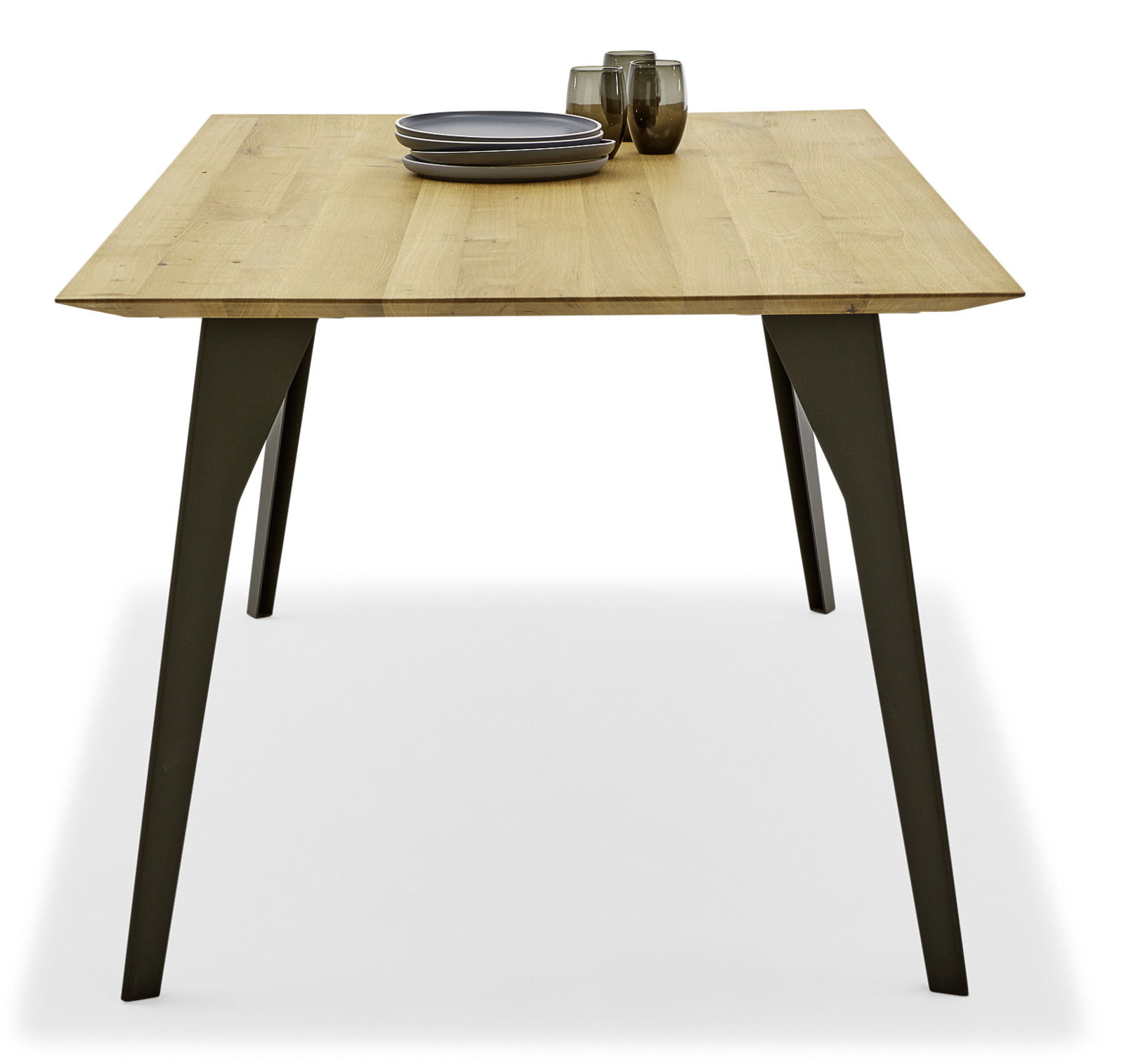 Moderner Esstisch aus Holz mit Metallbeinen, frontal fotografiert, mit Geschirr und Gläsern dekoriert.