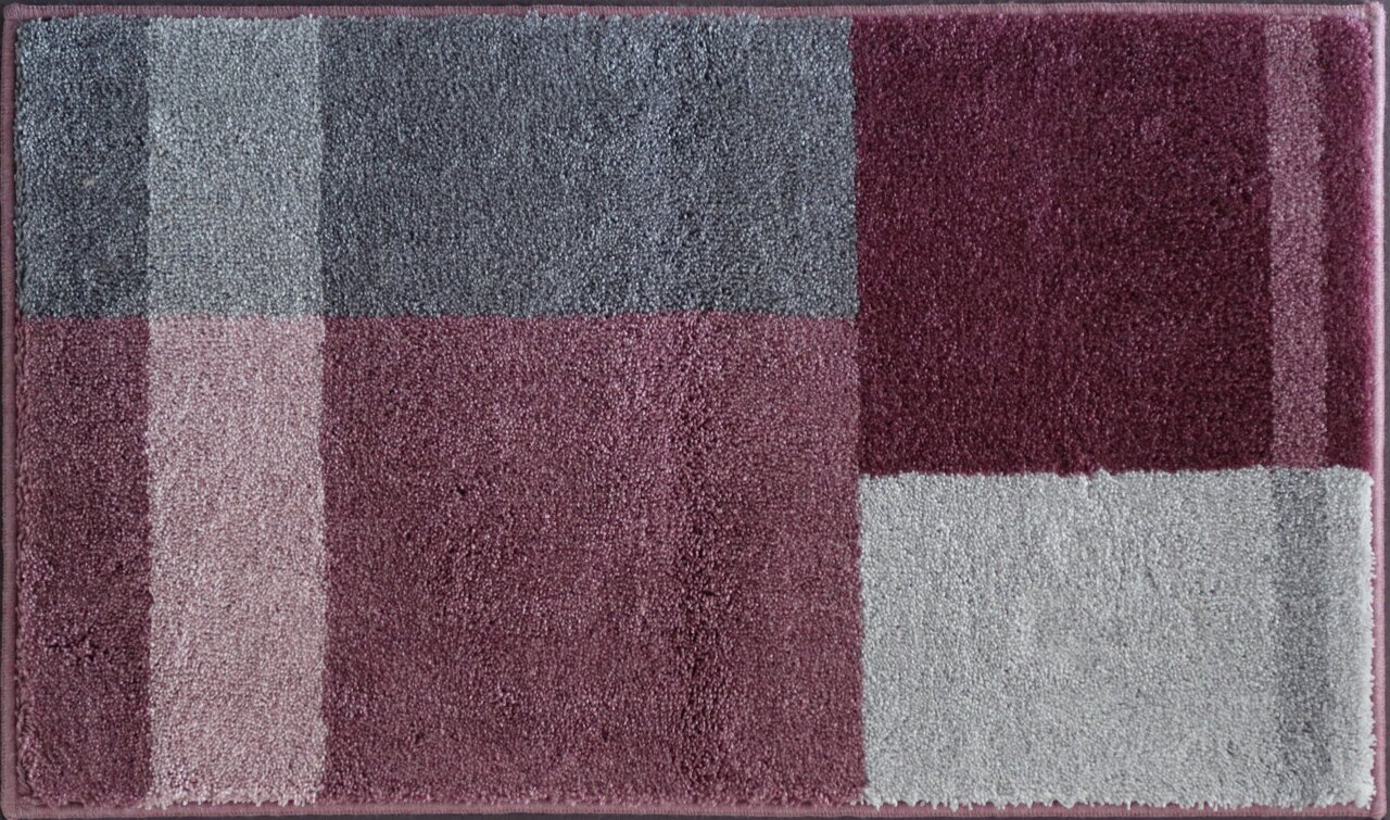 Badteppich in rechteckiger Form mit einem modernen, geometrischen Muster in verschiedenen Grautönen und Rotnuancen, aus der Vogelperspektive fotografiert.