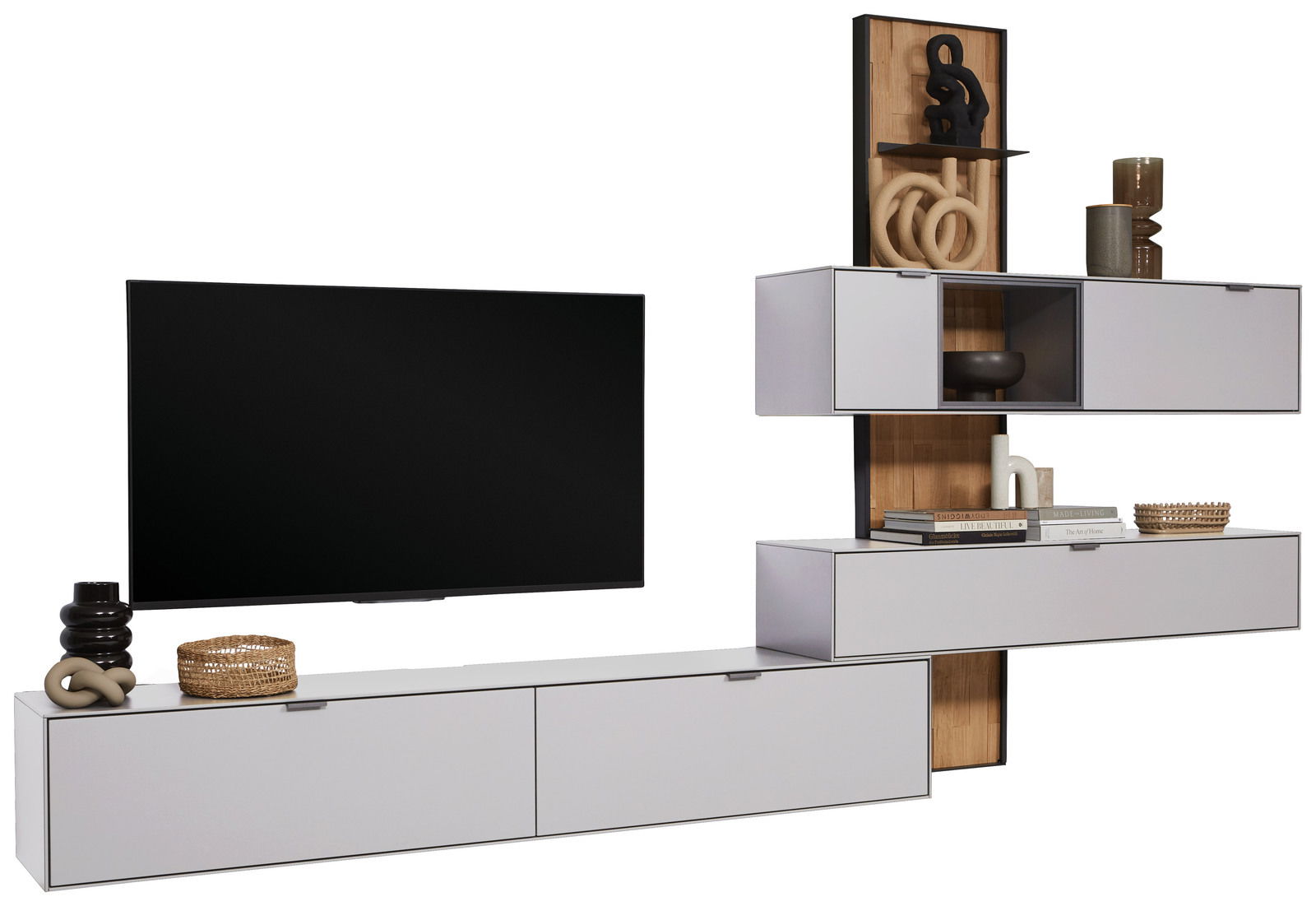 Moderne Wandkombination Dieter Knoll RINA in hellem Holz und Weiß, bestehend aus mehreren Schränken und Regalen, mit Dekorationen und einem großen Fernseher, seitliche Perspektive.