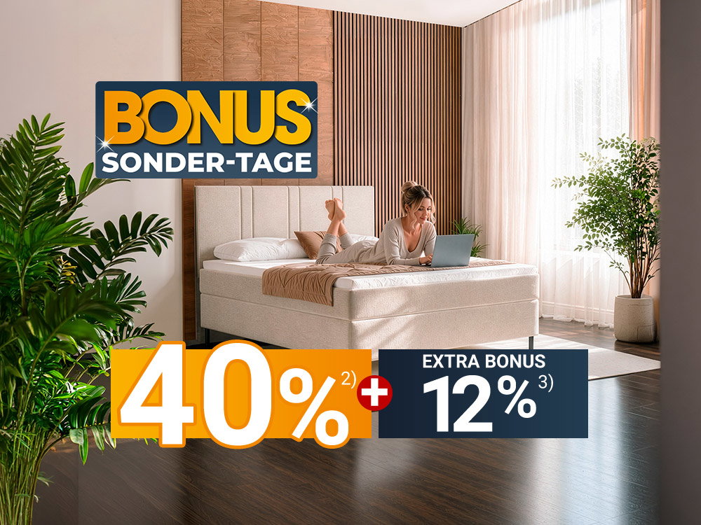 Frau liegt auf hellem Boxspringbett mit Laptop im modernen Schlafzimmer, Bonus-Sonder-Tage.