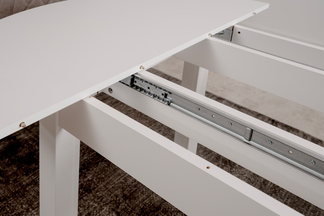 Close-up van een witte eettafel met uitschuifbaar tafelblad en een mechanisme met metalen rails.