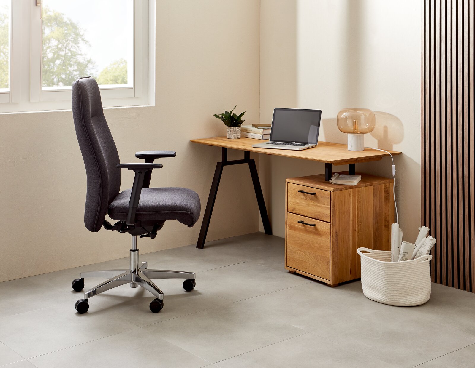 Moderner Schreibtisch aus Holz mit zwei Schubladen, Laptop und Lampe, seitliche Perspektive