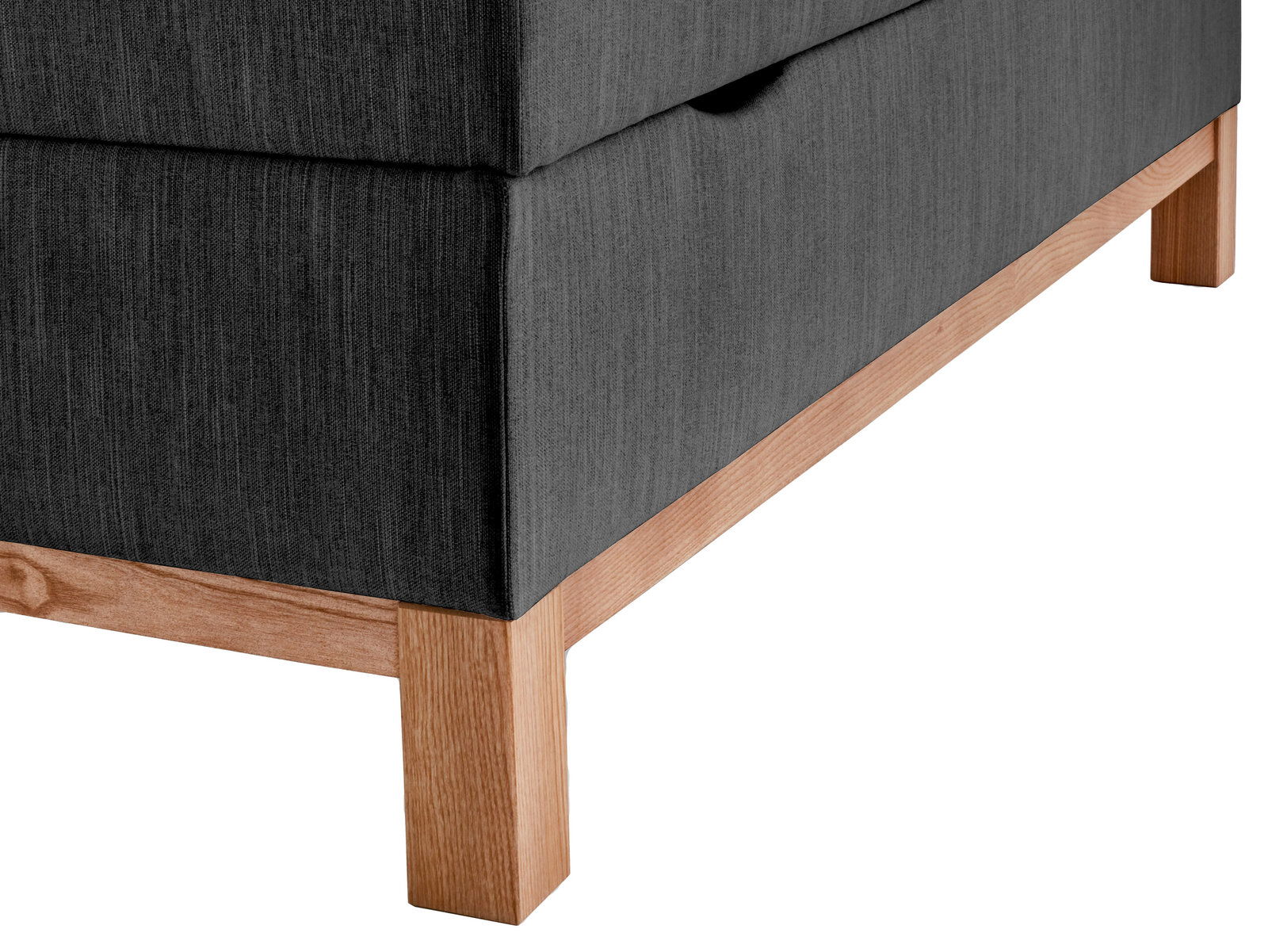 Nahaufnahme eines Boxspringbetts mit grauem Stoffbezug und Holzfüßen, seitliche Perspektive.