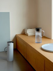 Stelton EM Kanne 1,5l in modernem Design, seitliche Perspektive auf einem Holztisch platziert.