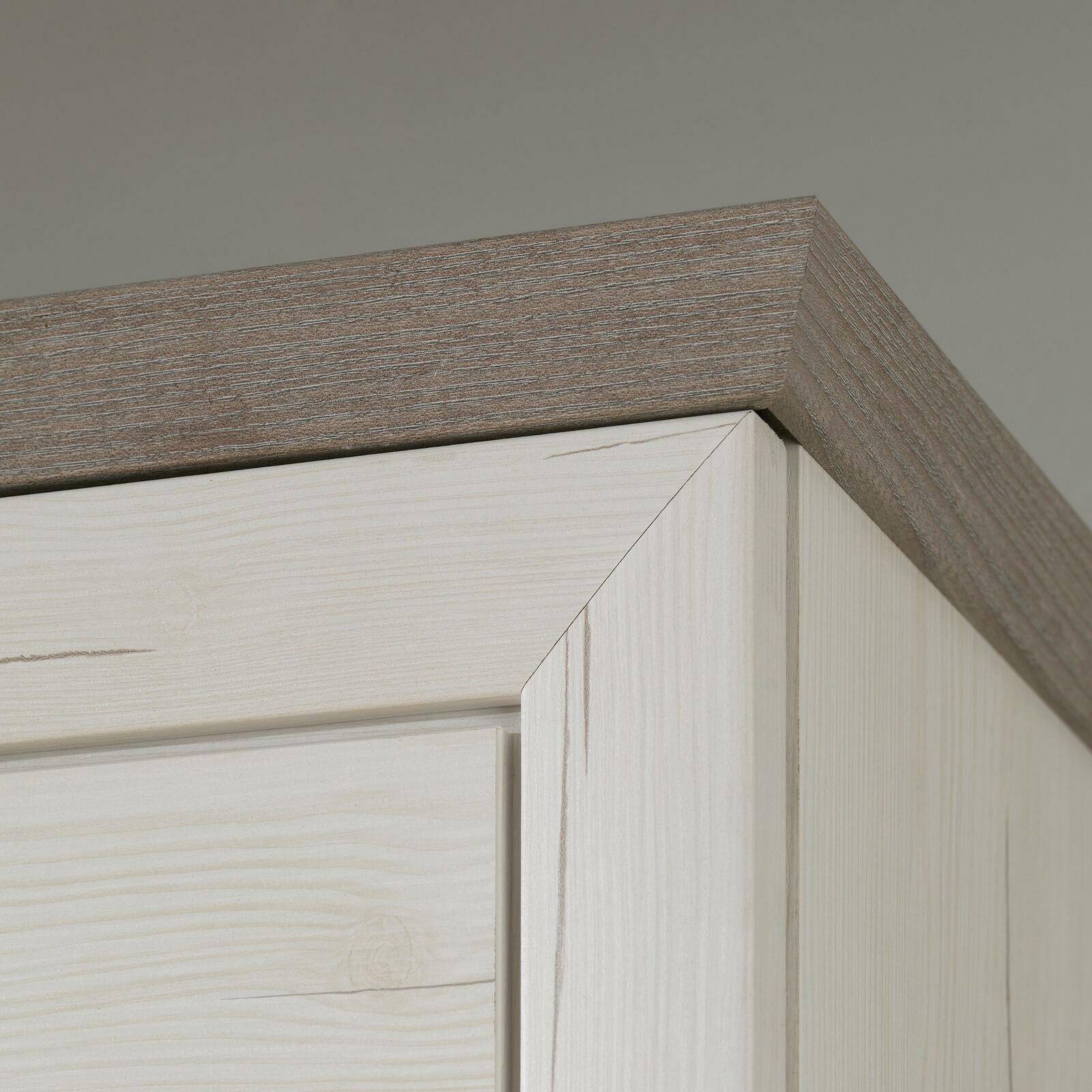 Nahaufnahme der oberen Ecke eines Schuhschranks aus hellem Holz mit dunklerer Holzleiste, Perspektive von unten.