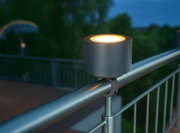 Geländerhalterung mit Akku-Windlicht, montiert auf einem Metallgeländer, seitliche Perspektive