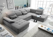 Graue Wohnlandschaft in U-Form mit verstellbaren Kopfstützen und Kissen, in einem modernen Wohnzimmer mit großen Fenstern und stilvoller Dekoration. Perspektive von oben links.