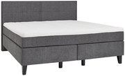 Graues Boxspringbett mit gepolstertem Kopfteil, seitliche Perspektive