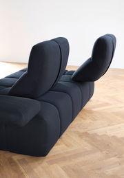Rückansicht einer modernen, dunkelblauen Eckgarnitur mit verstellbaren Rückenlehnen auf einem Holzboden.