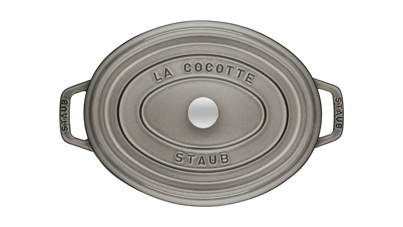 Ovale Cocotte von oben mit der Aufschrift 'La Cocotte Staub' auf dem Deckel, graue Farbe, mit zwei Griffen.