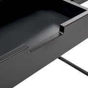 Nahaufnahme einer schwarzen Schublade einer Konsole, die von oben betrachtet wird.