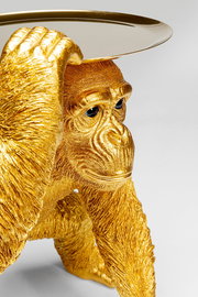 Goldene Deko-Figur eines Schimpansen in Butler-Pose, der ein Tablett auf dem Kopf balanciert. Perspektive von schräg vorne.