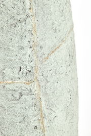 Nahaufnahme eines strukturierten, hellgrauen Topfes mit rauer Oberfläche und sichtbaren Nahtlinien.