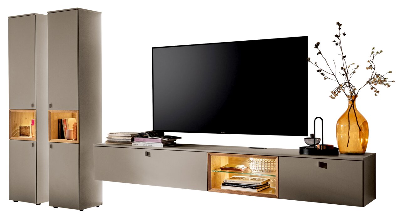 Moderne Wandkombination mit zwei hohen Schränken und einem breiten TV-Board, dekoriert mit Büchern und einer Vase, aus frontaler Perspektive.