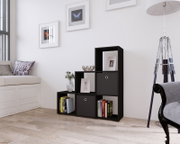 Schwarzes, stufenförmiges Regalwürfel-Regalsystem mit offenen Fächern und zwei Stoffboxen, dekoriert mit Büchern, Bilderrahmen und Vase im hellen Wohnzimmer; Perspektive: frontale Ansicht leicht von links.