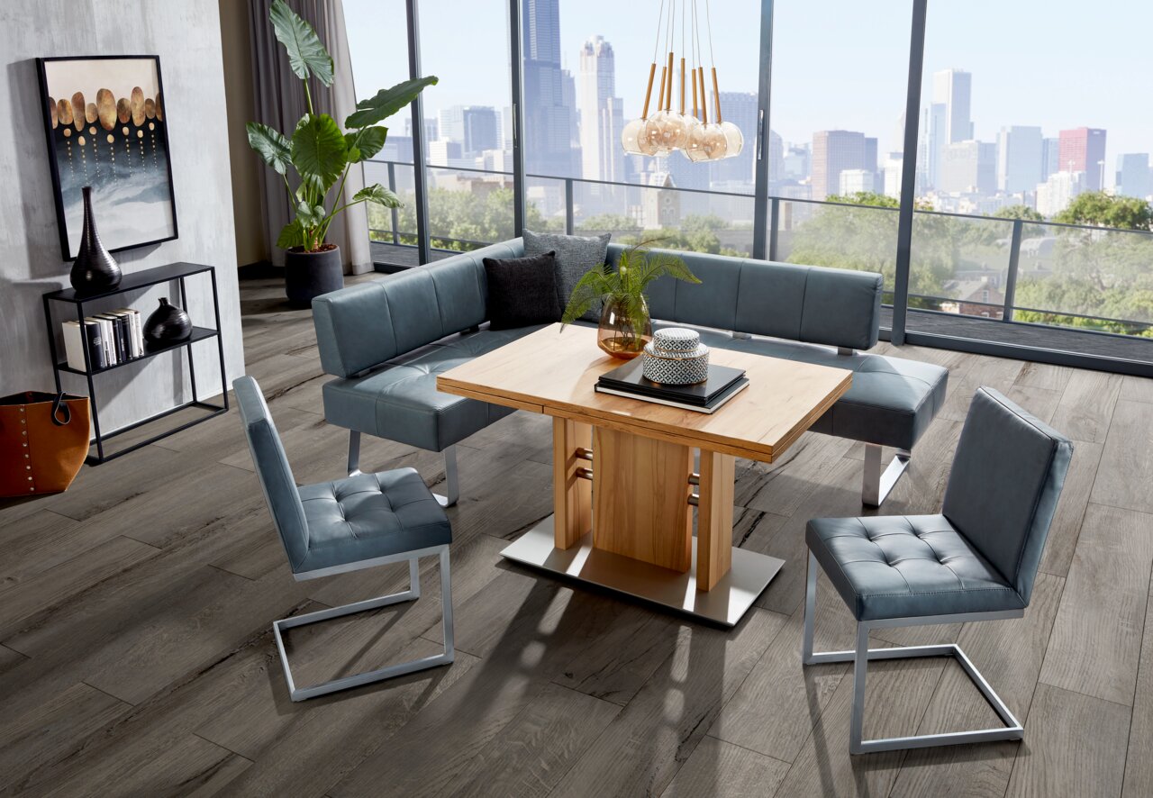 Moderano Eckbank LUPO II Moderne Essgruppe mit Eckbank und Freischwinger-Stühlen in einem hellen Raum mit Stadtblick, Perspektive von schräg oben.