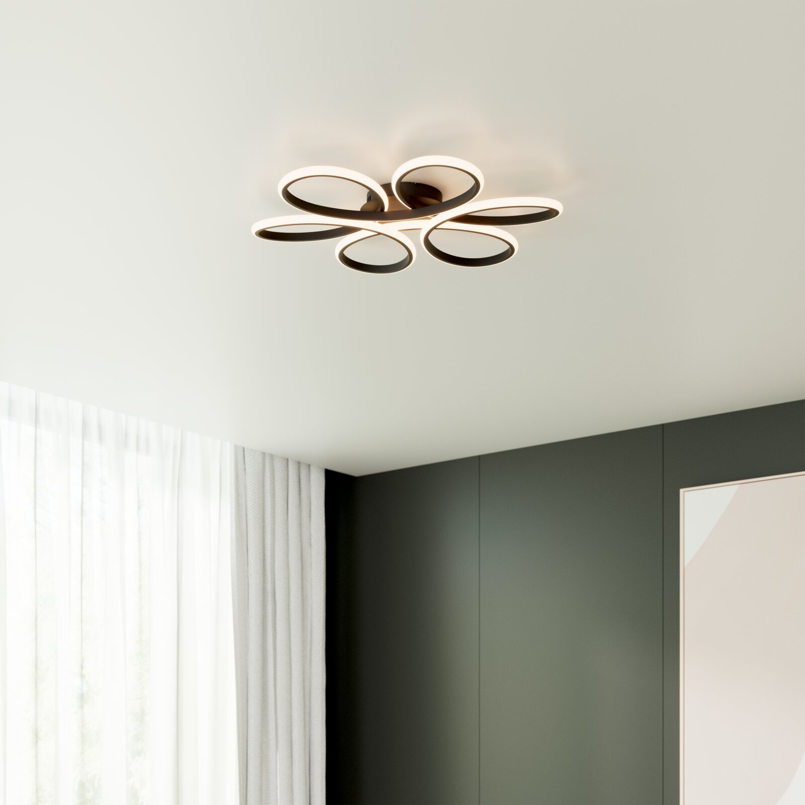 Moderne LED-Deckenleuchte in Blütenform mit fünf ovalen Leuchtringen in Schwarz/Weiß, warmweiß leuchtend, an weißer Zimmerdecke montiert, Perspektive von unten im Raum
