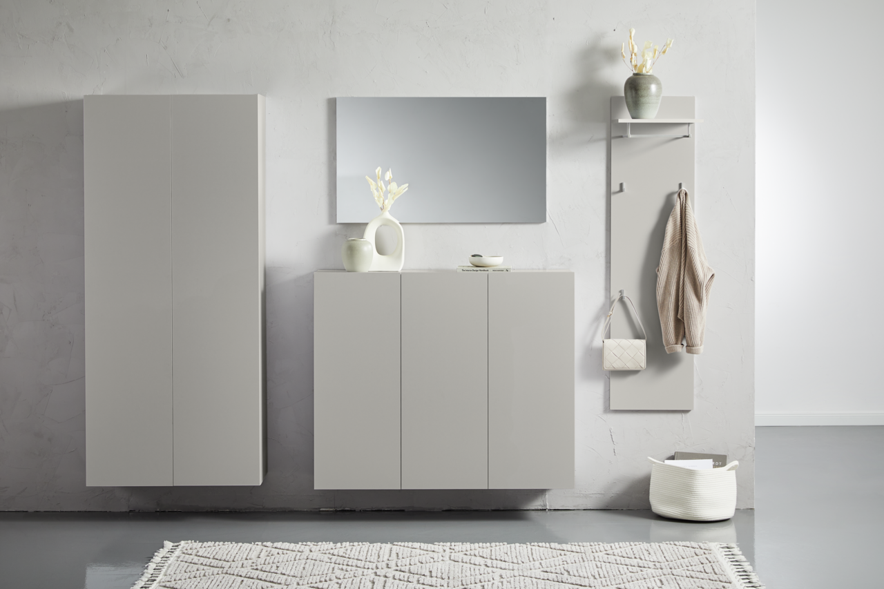 Moderner Hängeschuhschrank in hellem Grau, frontal fotografiert, mit dekorativen Elementen wie Vasen und Spiegel.