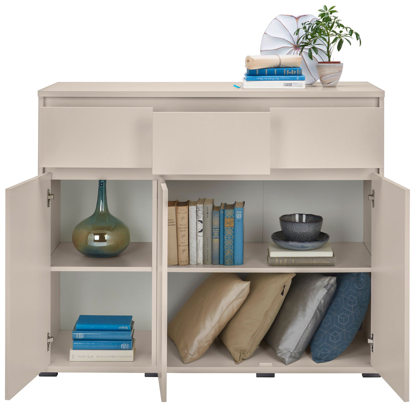 Beigefarbenes Sideboard mit geöffneter Frontansicht, zeigt dekorative Gegenstände wie Bücher, Kissen und Geschirr.