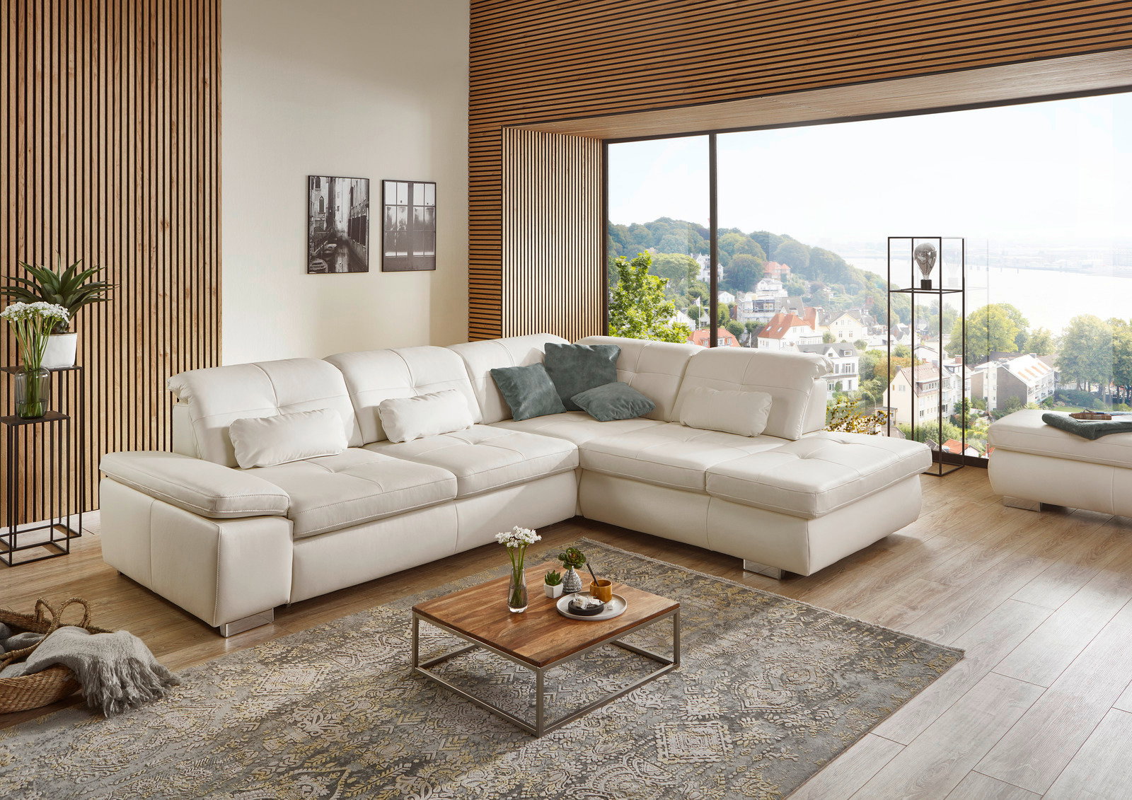 Beldomo Premium Ecksofa AUSTIN-L Moderne weiße Eckgarnitur in einem stilvollen Wohnzimmer mit Blick auf eine große Fensterfront und eine malerische Landschaft.